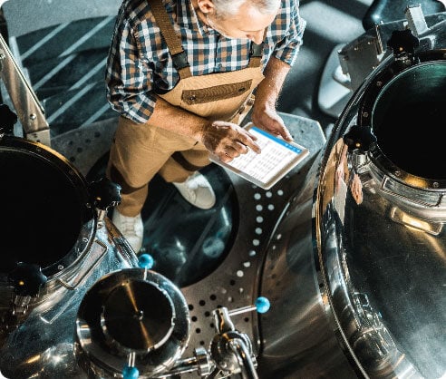 Employee in a beverage management warehouse examining a graph on a tablet