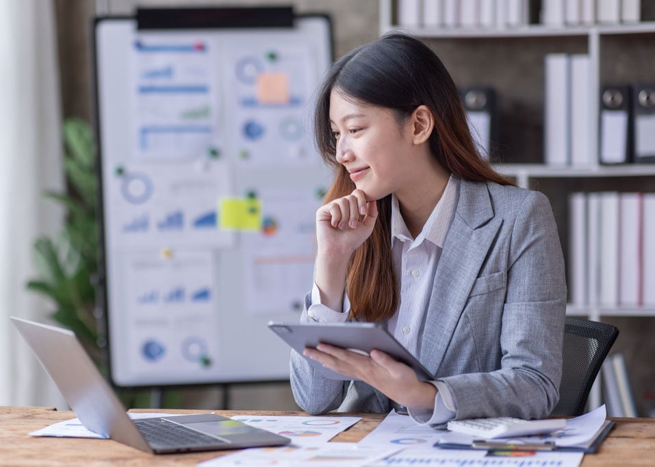 Femme heureuse et souriante regardant un ordinateur portable avec un tableau d'analyse en arrière-plan