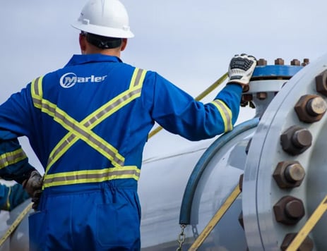 Employee in a Marler Integrity uniform and hardhat operates heavy machinery